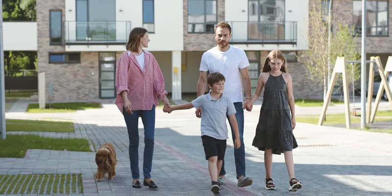 Family of four walking in front of appartment building