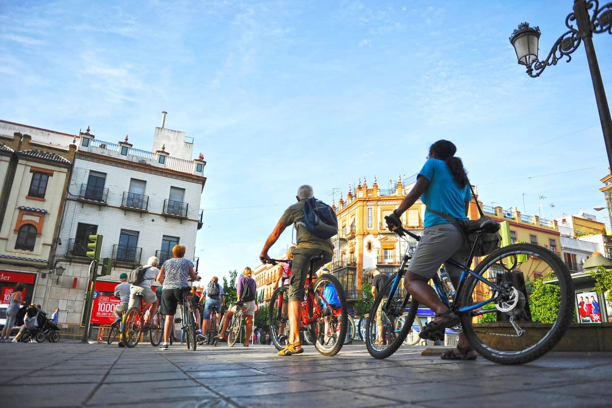 Tourists on bike tour through Triana neighborhood in Seville, Andalusia, Spain